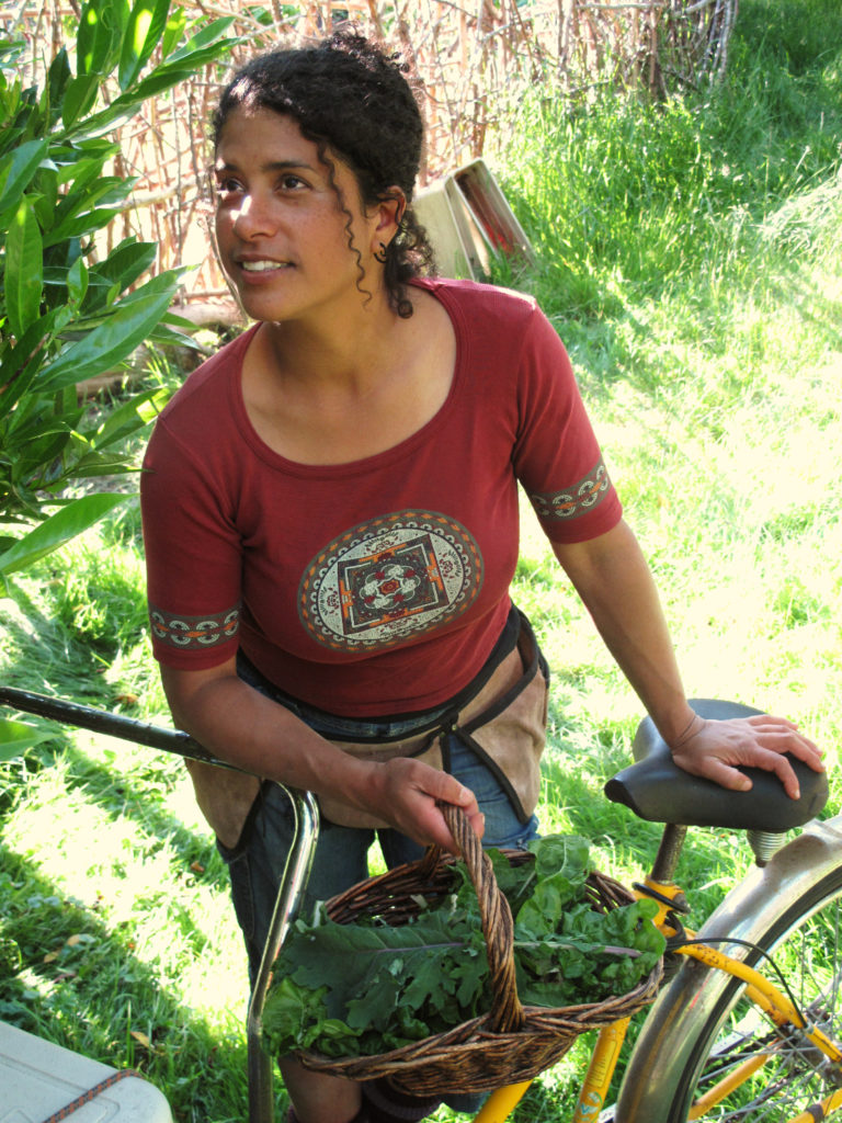 Romina with bike and basket of kale